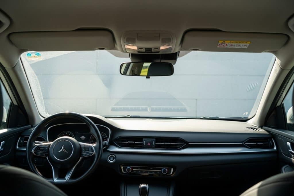 Intérieur de voiture avec vitres légèrement ouvertes pour éliminer la buée et renouveler l’air humide