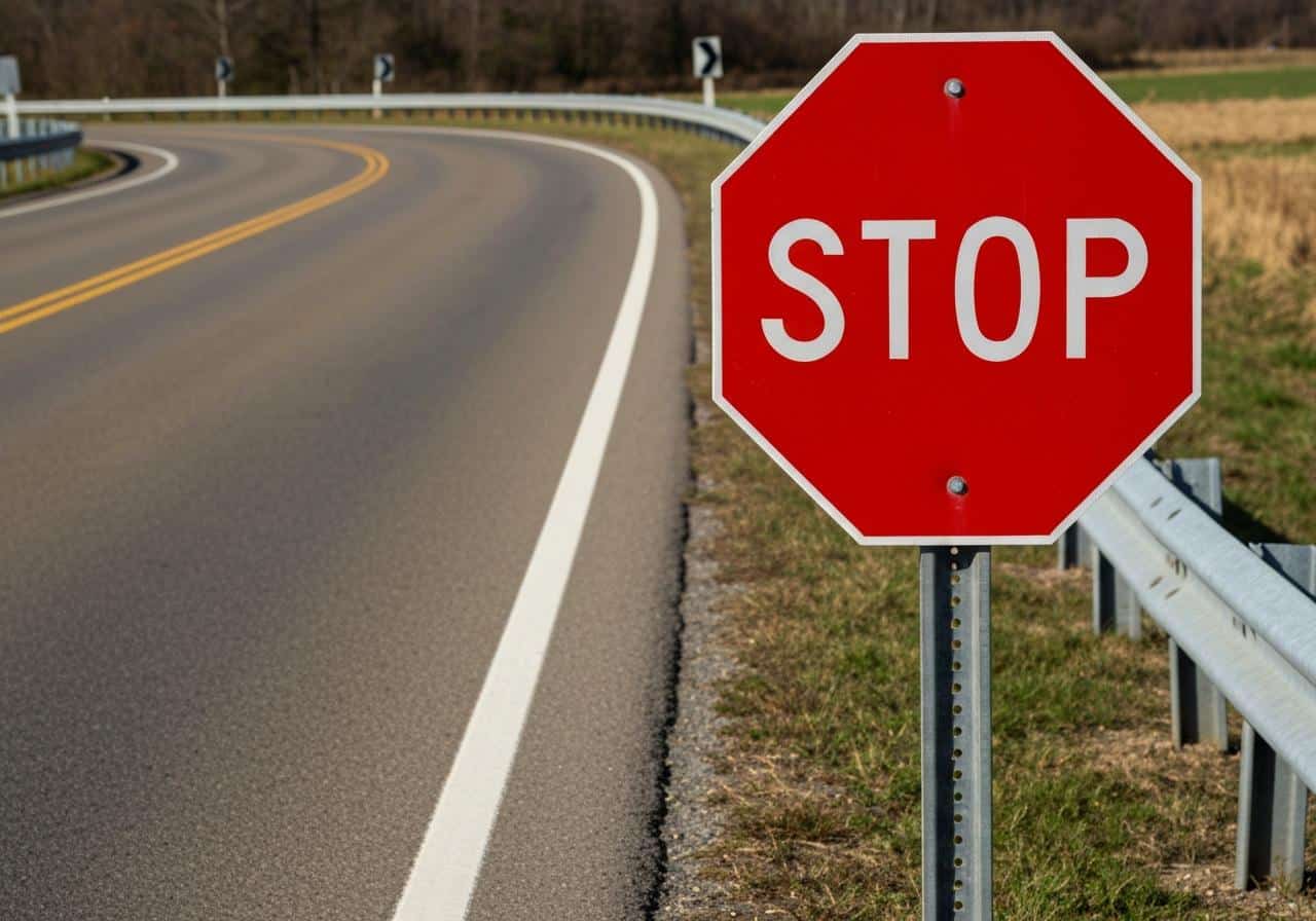 Panneau stop octogonal rouge au bord d'une route