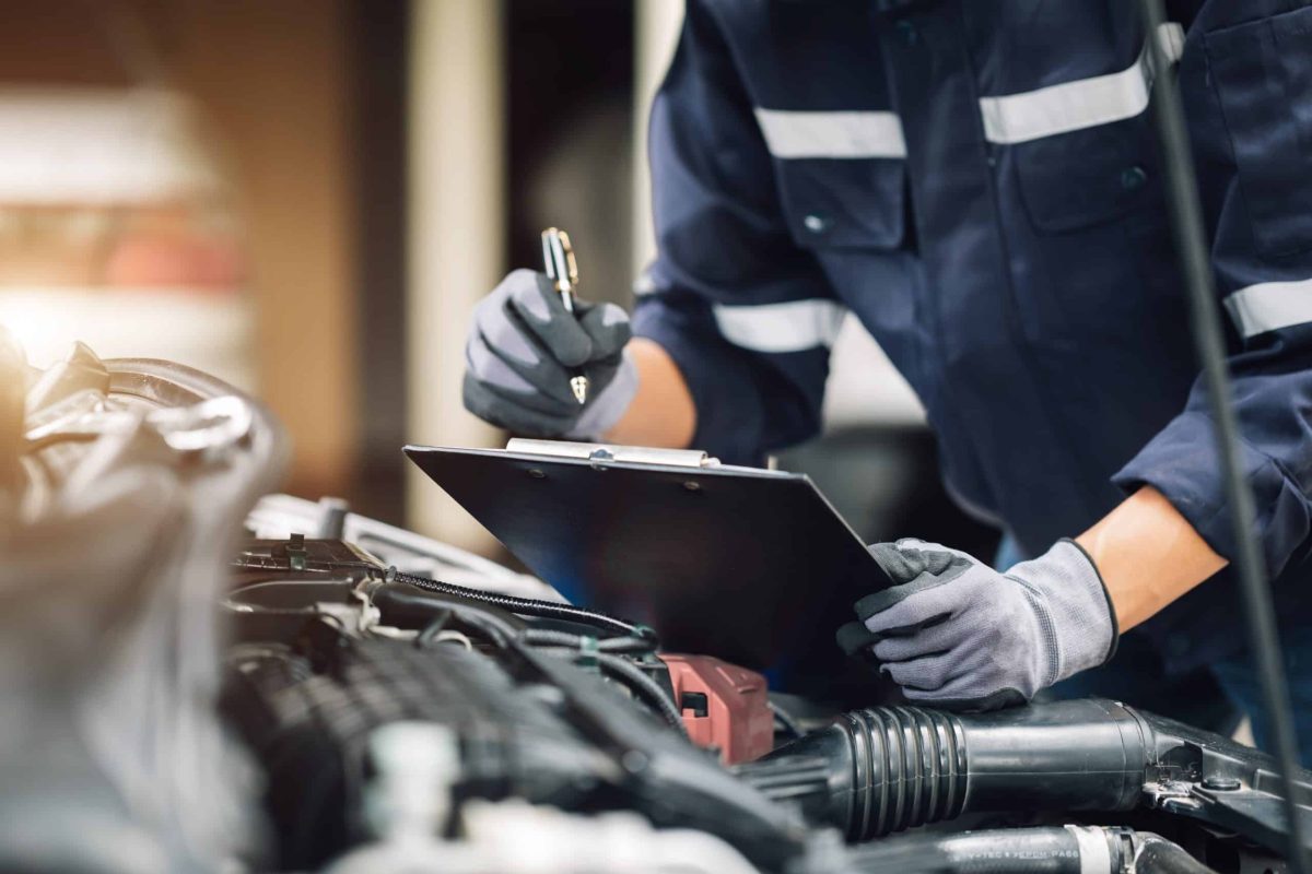 Un mécanicien travaille sur le moteur de la voiture dans le garage. Service de réparation.