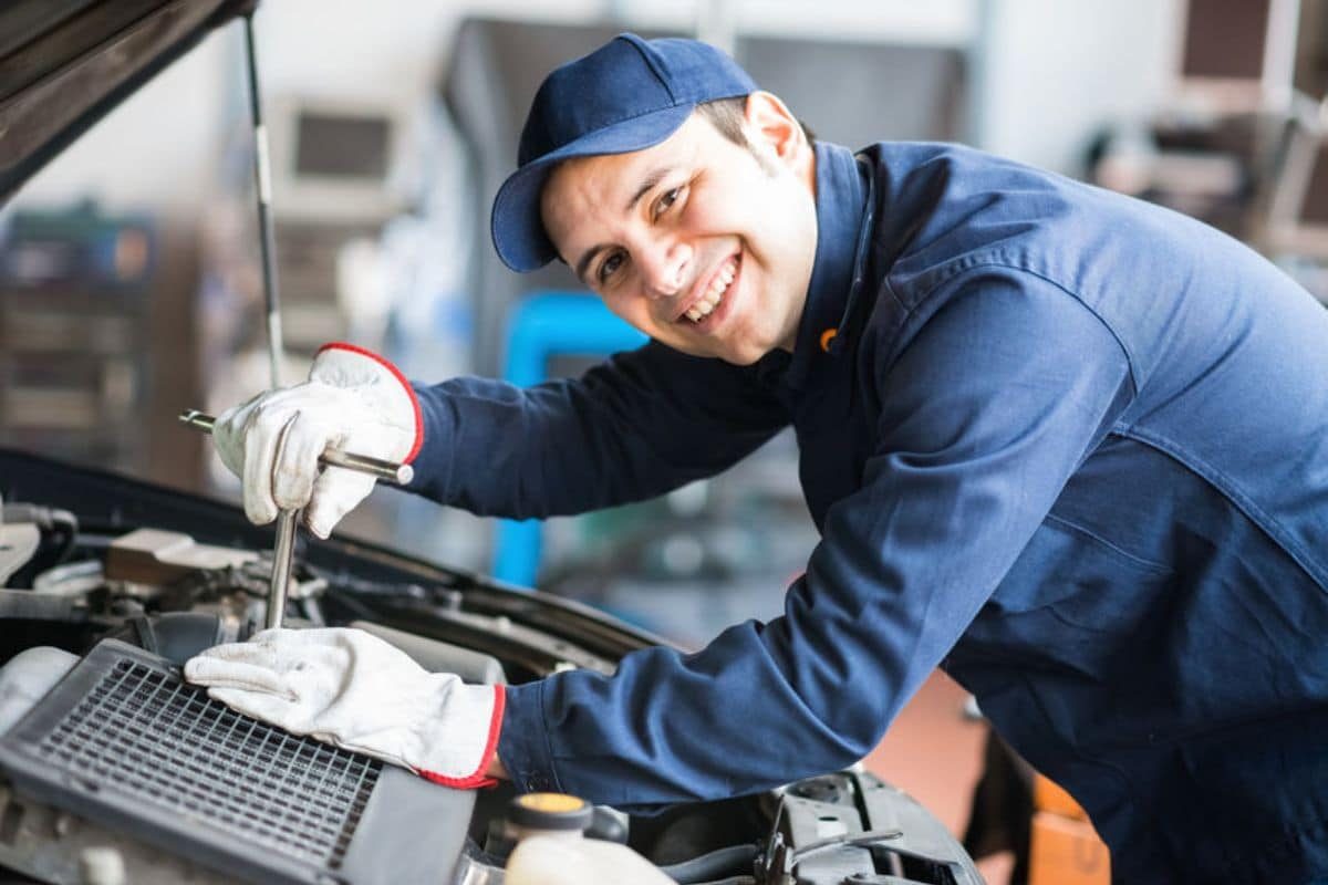Mécanicien souriant réparant un moteur